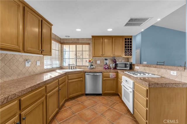 kitchen featuring light tile patterned flooring, sink, backsplash, kitchen peninsula, and stainless steel appliances