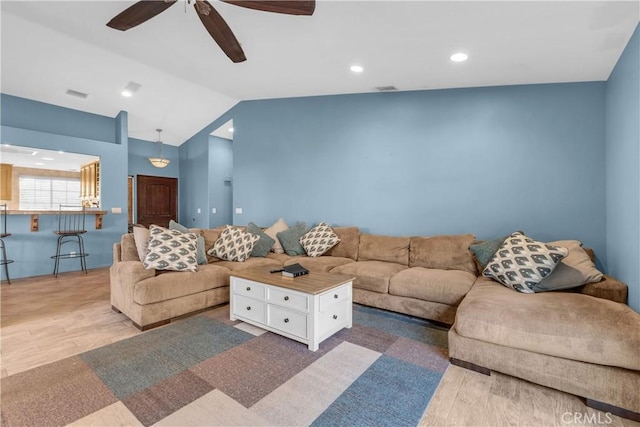 living room with lofted ceiling, wood-type flooring, and ceiling fan