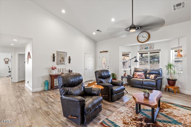 living room with high vaulted ceiling, light hardwood / wood-style floors, and ceiling fan