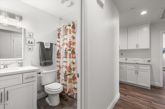 bathroom featuring vanity, hardwood / wood-style floors, walk in shower, and toilet