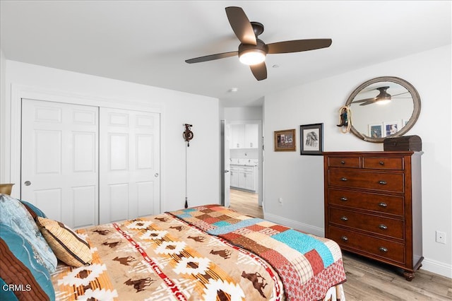 bedroom with ensuite bath, light hardwood / wood-style floors, a closet, and ceiling fan