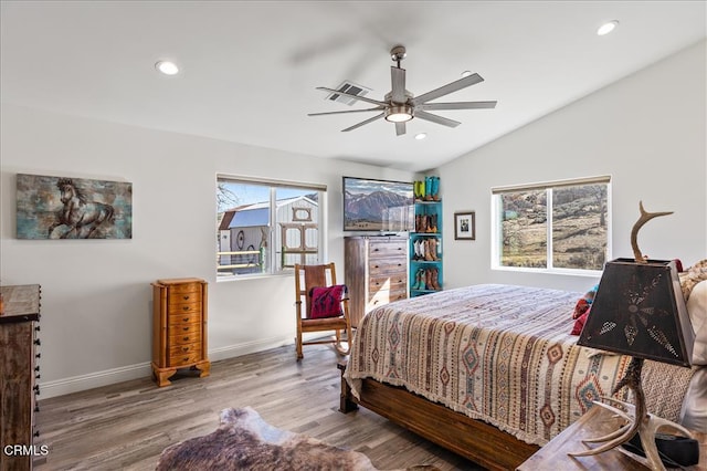 bedroom with hardwood / wood-style flooring, ceiling fan, and vaulted ceiling