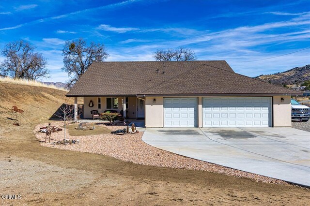 17600 Ascot Ct, Tehachapi, CA 93561 - view of front of home with covered porch, driveway, an attached garage, and stucco siding