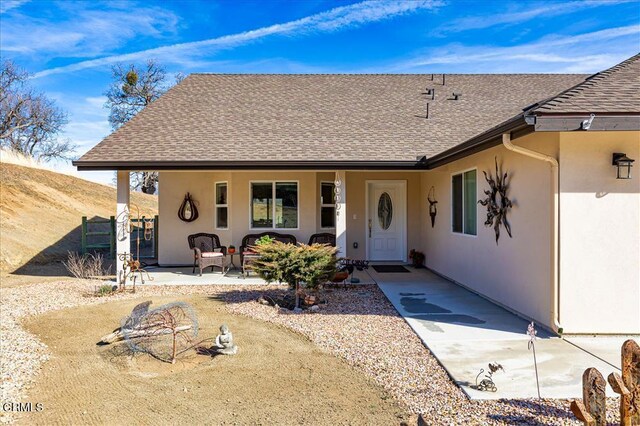 17600 Ascot Ct, Tehachapi, CA 93561 - view of exterior entry featuring roof with shingles, stucco siding, and a porch