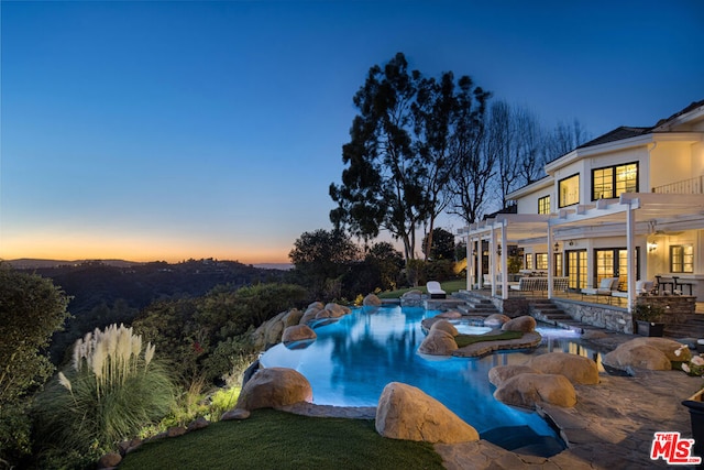 pool at dusk with a patio, a yard, and a pergola