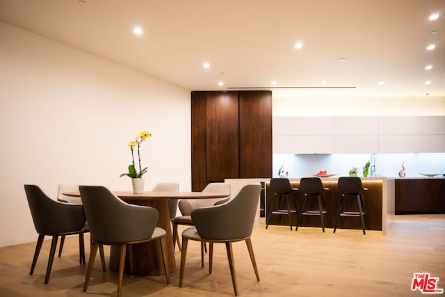 dining room with bar and light hardwood / wood-style flooring