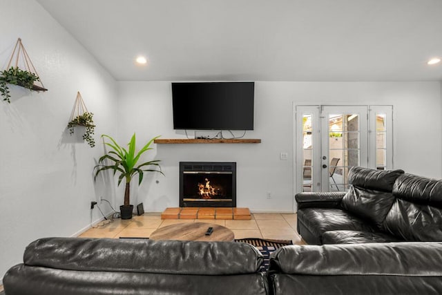 living room with french doors, a tile fireplace, and light tile patterned floors