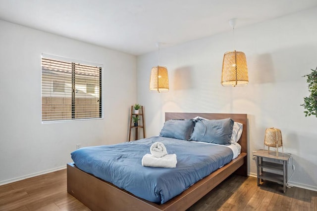 bedroom with dark hardwood / wood-style flooring