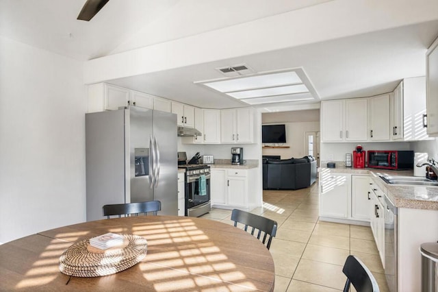 kitchen with stainless steel appliances, sink, light tile patterned floors, and white cabinets