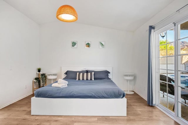 bedroom with wood-type flooring and vaulted ceiling