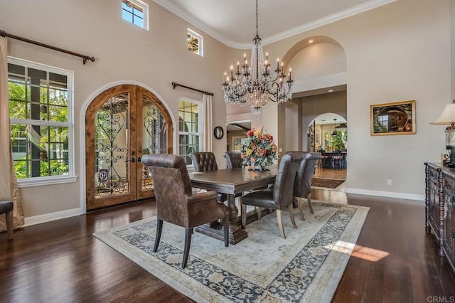 dining room featuring french doors, a chandelier, ornamental molding, dark hardwood / wood-style flooring, and a high ceiling