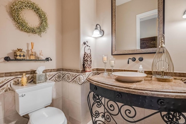 bathroom with tile walls, vanity, and toilet