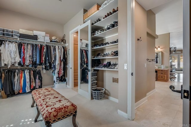 walk in closet featuring light carpet