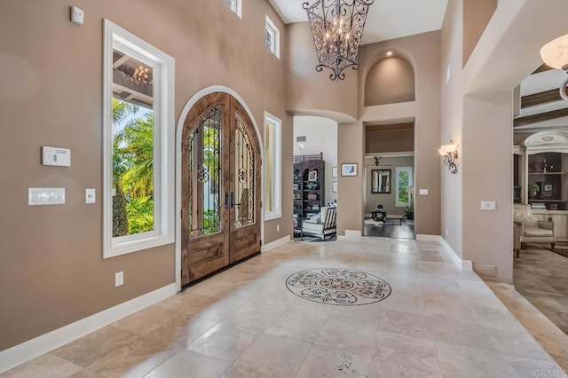 entryway featuring a high ceiling, a chandelier, and french doors