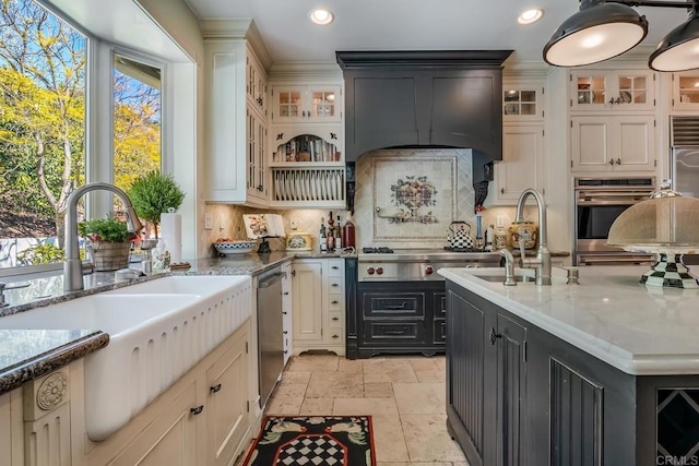 kitchen with tasteful backsplash, sink, light stone counters, and appliances with stainless steel finishes