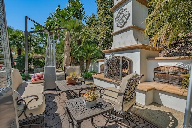 view of patio with exterior fireplace