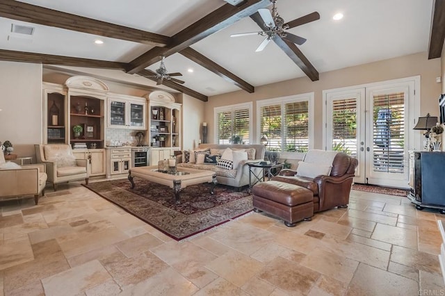 living room with a wealth of natural light, lofted ceiling with beams, french doors, and ceiling fan