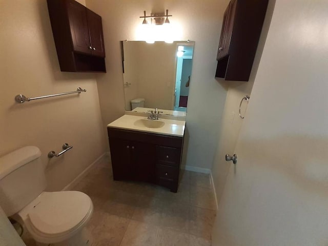 bathroom with tile patterned flooring, vanity, and toilet