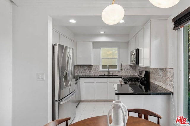 kitchen with white cabinetry, sink, decorative backsplash, and stainless steel appliances