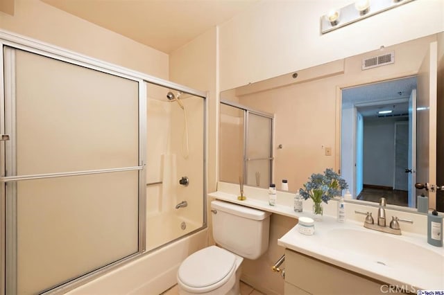 full bathroom featuring vanity, combined bath / shower with glass door, and toilet