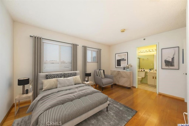 bedroom featuring hardwood / wood-style flooring and ensuite bath