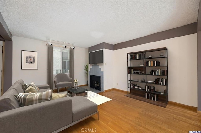 living room featuring track lighting, a textured ceiling, and light wood-type flooring