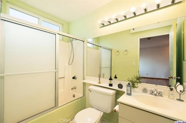 full bathroom featuring vanity, shower / bath combination with glass door, and toilet