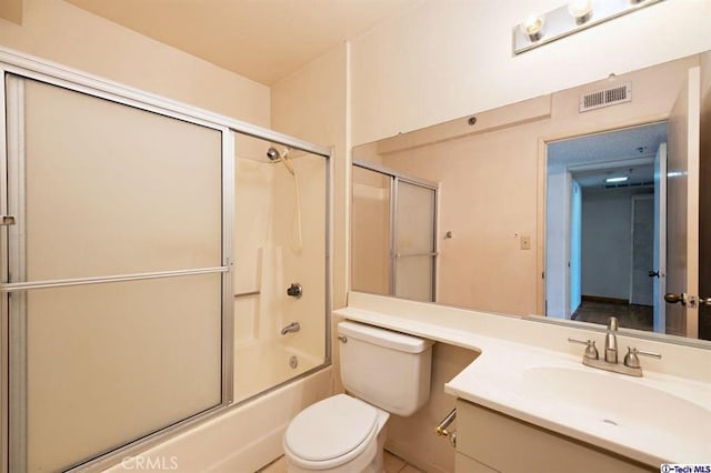 full bathroom featuring bath / shower combo with glass door, vanity, and toilet