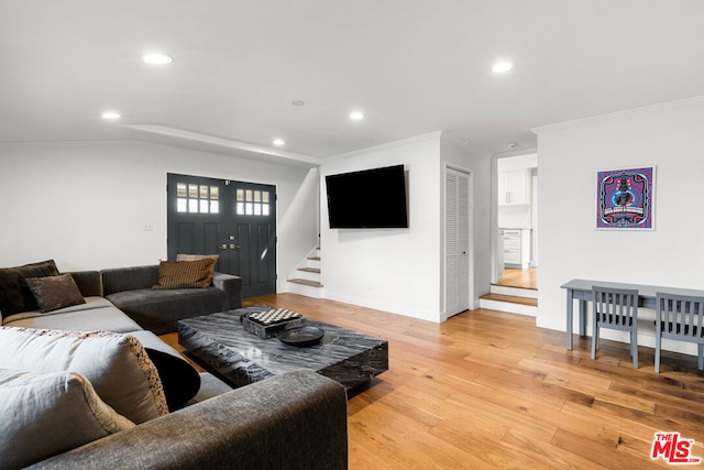 living room with ornamental molding and light wood-type flooring