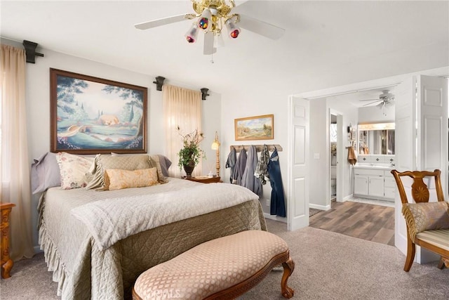 carpeted bedroom with ensuite bathroom and ceiling fan