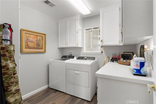 laundry room with dark hardwood / wood-style floors, cabinets, and washing machine and clothes dryer