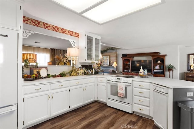 kitchen with dark wood-type flooring, white appliances, kitchen peninsula, and white cabinets