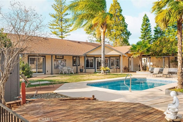 view of swimming pool featuring a wooden deck and a patio