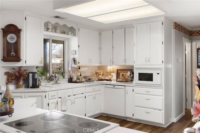 kitchen with dark hardwood / wood-style flooring, sink, white cabinets, and white appliances