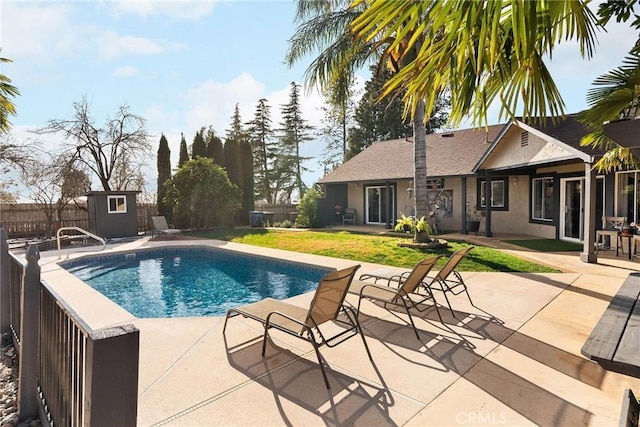 view of pool featuring a patio and a storage shed