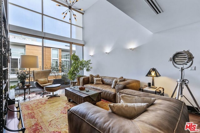 living room featuring a towering ceiling and a chandelier