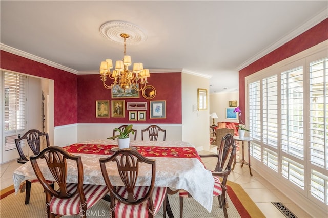 dining room with light tile patterned flooring, ornamental molding, and a chandelier