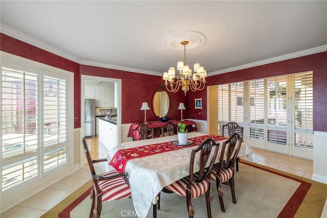 dining space featuring a wealth of natural light, ornamental molding, light tile patterned floors, and an inviting chandelier