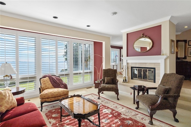 living room with a tile fireplace, ornamental molding, and light colored carpet