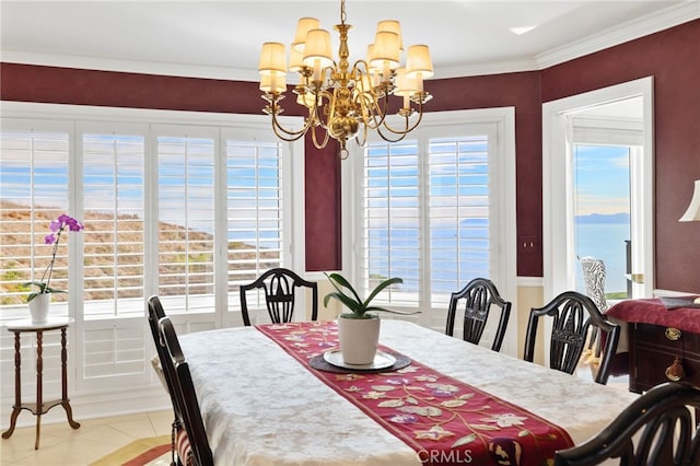 dining space featuring light tile patterned flooring, ornamental molding, a chandelier, and a water view