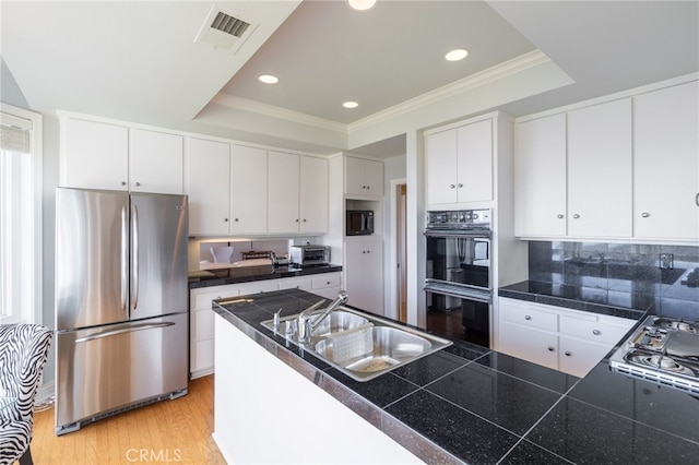 kitchen with white cabinetry, a tray ceiling, sink, and black appliances