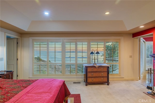 carpeted bedroom with a tray ceiling