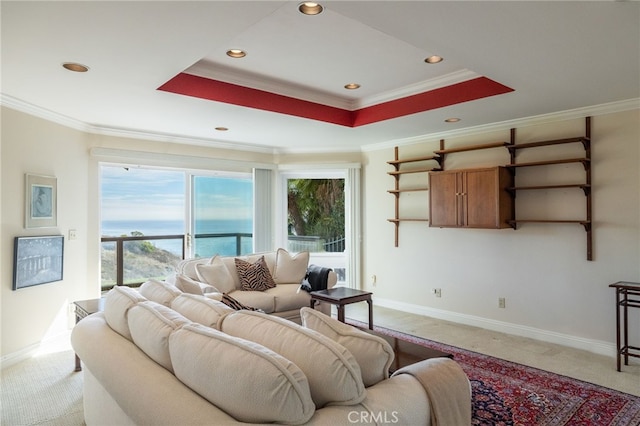 carpeted living room with a water view, ornamental molding, and a raised ceiling