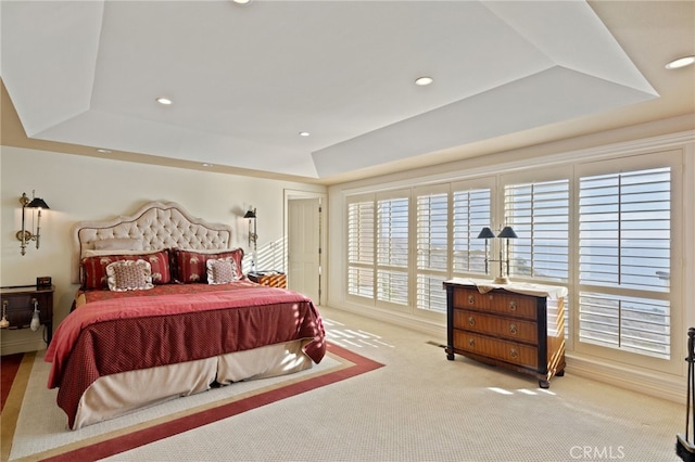 carpeted bedroom featuring a raised ceiling