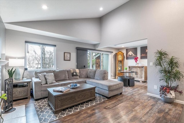 living room featuring a wealth of natural light, high vaulted ceiling, and dark hardwood / wood-style floors