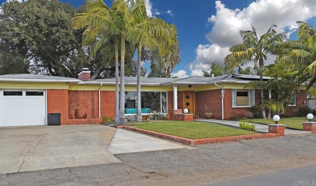 ranch-style home featuring a front lawn, an attached garage, and brick siding