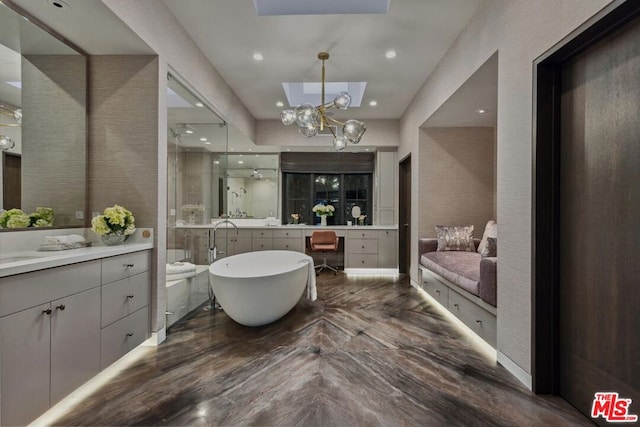 bathroom with vanity, an inviting chandelier, and a bathtub