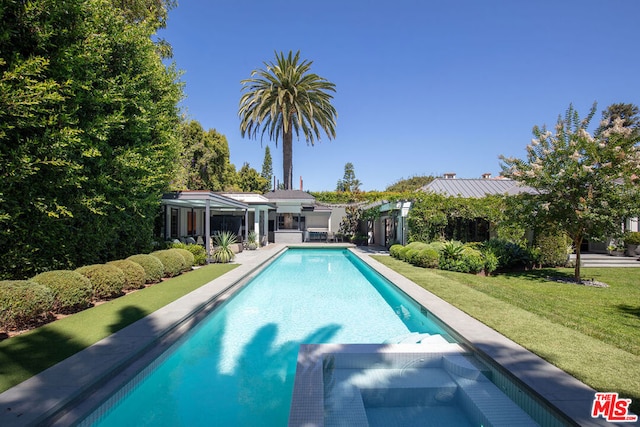 view of swimming pool with an outbuilding and a yard