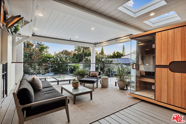 sunroom / solarium featuring beam ceiling, wood ceiling, and a skylight