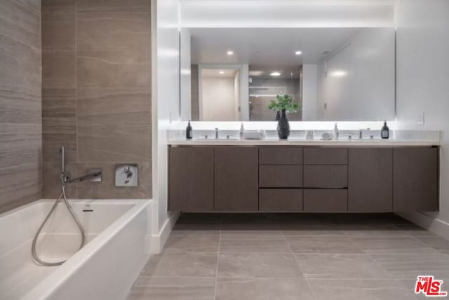 bathroom featuring vanity, tile patterned flooring, and a washtub